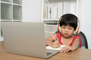 contento asiatico ragazza alunno in linea apprendimento classe a partire dal un' computer con un' insegnante, in linea formazione scolastica è un' tecnologia per sociale distanza nel un' nuovo normale stile di vita, concetto di casa scuola e precettore foto