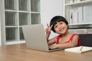 contento asiatico ragazza alunno in linea apprendimento classe a partire dal un' computer con un' insegnante, in linea formazione scolastica è un' tecnologia per sociale distanza nel un' nuovo normale stile di vita, concetto di casa scuola e precettore foto