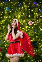 bella asiatico ragazza nel Santa costume per Natale con notte leggero foto