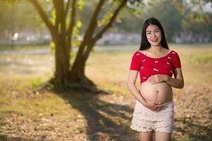 immagine di una donna incinta che si tocca il ventre con le mani foto