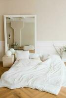 Camera da letto interno nel scandinavo stile. un' letto su il pavimento con bianca biancheria e cuscini foto