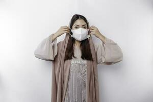 un' prudente asiatico musulmano donna indossare un' maschera come un' preventivo per covid-19 foto