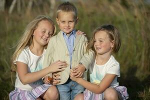 contento famiglia sorelle e poco fratello su un' estate prato. foto