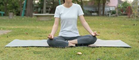 donna praticante meditare su il parco. asiatico donna fare esercizi nel mattina. equilibrio, ricreazione, rilassamento, calma, bene Salute, felice, relax, salutare stile di vita, ridurre fatica, tranquillo, calmo, atteggiamento. foto