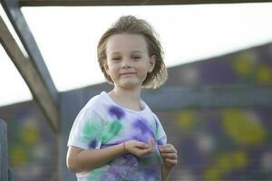 il bambino giochi nel il cortile. un' ragazza di cinque nel un' luminosa maglietta. foto