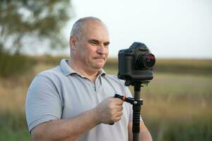 un' maschio operatore video con un' telecamera e un' stadio nel il suo mani. foto