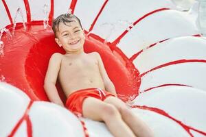 immagine di giovane ragazzo giocando nel all'aperto acqua parco foto