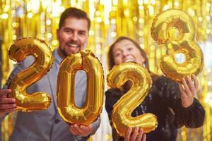 coppia a nuovo anno vigilia festa con oro palloncini foto