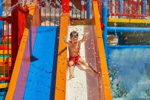 immagine di giovane ragazzo giocando nel all'aperto acqua parco foto