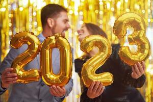 coppia a nuovo anno vigilia festa con oro palloncini foto