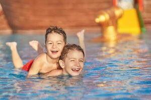 immagine di fratelli giocando nel all'aperto acqua parco piscina foto