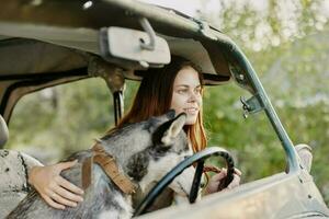 donna e sua rauco cane felicemente in viaggio nel auto Sorridi con denti autunno camminare con animale domestico, viaggio con cane amico foto