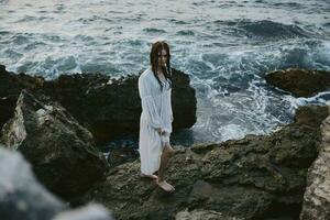 attraente donna nel bianca vestito a il mare spiaggia natura foto