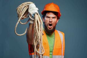 un' uomo nel un' Lavorando uniforme con un' corda nel il suo mani emozioni costruzione stile di vita foto