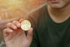 vicino su di bitcoin è tenuto di uomo con sfocatura sfondo. criptovaluta commercio concetto. selettivo messa a fuoco Immagine foto