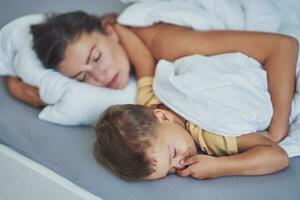 giovane madre con 4 anni vecchio figlio nel letto foto