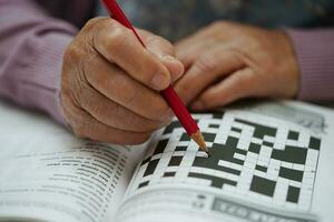 asiatico anziano donna giocando sudoku puzzle gioco per pratica cervello formazione per demenza prevenzione, alzheimer patologia. foto