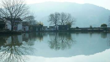 uno vecchio tradizionale Cinese villaggio Visualizza con il vecchio arcuato pietra ponte e vecchio di legno edifici nel il meridionale campagna di il Cina foto