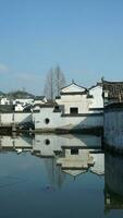 uno vecchio tradizionale Cinese villaggio Visualizza con il vecchio arcuato pietra ponte e vecchio di legno edifici nel il meridionale campagna di il Cina foto