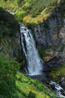 cascata di montagna cascata, alta montagna vegetazione - verde alberi e cespugli foto