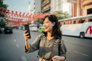 giovane asiatico donna zaino viaggiatore godendo Cina cittadina strada cibo mercato nel bangkok, Tailandia. viaggiatore controllo su lato strade. foto