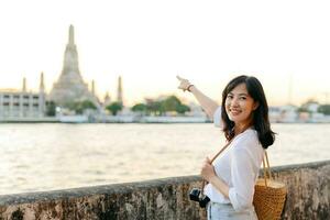 ritratto giovane bellissimo asiatico donna sorridente mentre viaggio a wat arun tramonto Visualizza punto, bangkok, Tailandia. foto