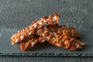 fritte Bacon strisce su il pietra buio tavola foto