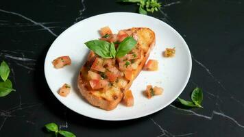 Bruschetta su un' bianca piatto, con un' nero marmo sfondo foto