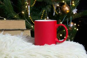 vuoto rosso boccale con Natale albero su sfondo, stuoia tè o caffè tazza con Natale e nuovo anno decorazione, orizzontale finto su con ceramica boccale per caldo bevande, vuoto regalo Stampa modello foto