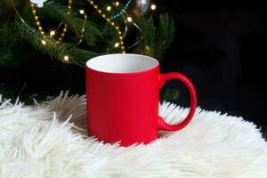 vuoto rosso boccale con Natale albero su sfondo, stuoia tè o caffè tazza con Natale e nuovo anno decorazione, orizzontale finto su con ceramica boccale per caldo bevande, vuoto regalo Stampa modello foto