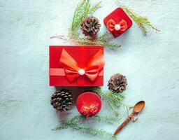 Natale decorazione composizione su bianca sfondo con un' bellissimo rosso regalo scatola con rosso nastro, albero rami, e pino coni foto
