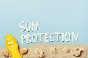 giallo tubo con contento protezione solare viso con sole protezione parola su blu sfondo. ultravioletto protezione cosmetici creativo concetto foto