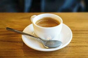 un' bianca tazza di caffè su un' di legno tavolo foto