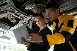 ingegneri e auto riparazione tecnici dovere uso tecnologia per individuare difetti nel il operazione di il motore di cliente macchine portato per riparazione nel il box auto. foto