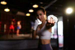 ritratto di donna apprendimento muay tailandese per costruire su il forza di il corpo e uso esso per difesa personale. siamo utilizzando mano impacchi prima mettendo su boxe guanti per boxe foto