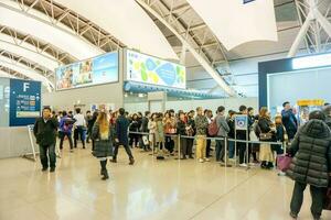 osaka, Giappone, 2018- molti persone e turisti in attesa nel linea per partire per cancello nel il kansai internazionale aeroporto per ritorno loro nazione dopo in viaggio nel Giappone. foto