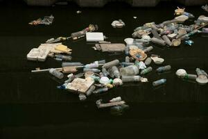 bangkok, thailandia-aprile 22,2023- plastica bottiglia e schiuma contenitore galleggiante su sporco fogne. foto