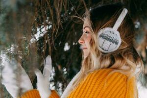 adolescente bionda nel un' giallo maglione al di fuori nel inverno. un' adolescenziale ragazza su un' camminare nel inverno Abiti nel un' nevoso foresta foto