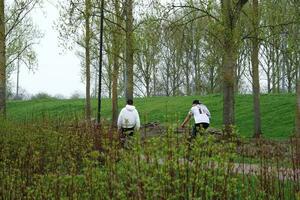 Basso angolo Visualizza di volontà lago parco con Locale e turista pubblico godendo il bellezza di lago e parco di a piedi in giro con loro famiglie. metraggio era catturato su 09-aprile-2023 a Milton keynes UK foto