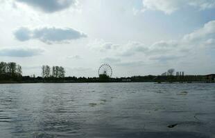 Basso angolo Visualizza di volontà lago parco con Locale e turista pubblico godendo il bellezza di lago e parco di a piedi in giro con loro famiglie. metraggio era catturato su 09-aprile-2023 a Milton keynes UK foto