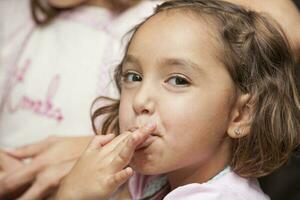 bellissimo ragazza cottura al forno cupcakes e avendo divertimento a casa. degustazione il cupcakes Impasto. foto