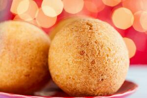 tradizionale colombiano bunuelos. in profondità fritte formaggio pane su Natale rosso sfondo foto