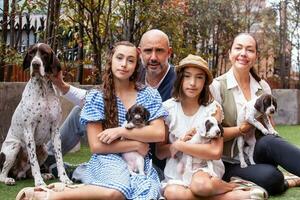 giovane famiglia all'aperto con loro nuovo Nato cuccioli nel un' soleggiato giorno foto