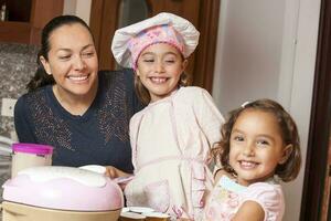 madre e figlie avendo divertimento nel il cucina cottura al forno insieme. preparazione cupcakes con mamma foto