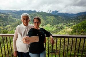 anziano madre e adulto figlia in viaggio insieme a il bellissimo Visualizza punto al di sopra di il cocco valle a salentino, collocato su il regione di quindio nel Colombia foto