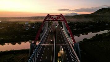 aereo Visualizza di il kalikuto ponte, un iconico rosso ponte a trans Giava Pedaggio strada, batang quando Alba. centrale Giava foto
