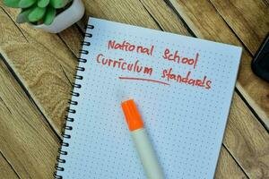 concetto di nazionale scuola programma scolastico standard Scrivi su libro isolato su di legno tavolo. foto