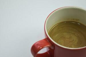 vicino su caldo cappuccino caffè nel un' rosso tazza isolato su un' bianca sfondo foto