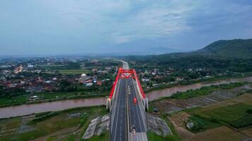 aereo Visualizza di il kalikuto ponte, un iconico rosso ponte a trans Giava Pedaggio strada, batang quando Alba. centrale Giava, Indonesia, dicembre 6, 2021 foto