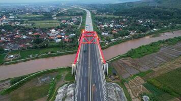 aereo Visualizza di il kalikuto ponte, un iconico rosso ponte a trans Giava Pedaggio strada, batang quando Alba. centrale Giava, Indonesia, dicembre 6, 2021 foto